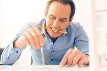 Experienced nice architect holding a pencil