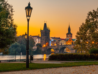 Embankment with old lamp in Old Town of Prague with Charles Bridge and Vltava river. Early morning...
