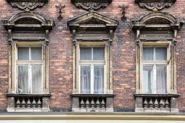 Fototapeta na wymiar Three vintage Windows on the facade of the old brick house