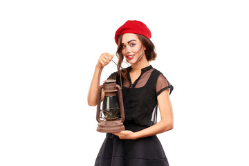 Studio portrait of young woman in Halloween costume posing with lantern