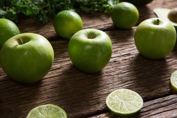 Green apple and sliced lemon arranged on wooden table