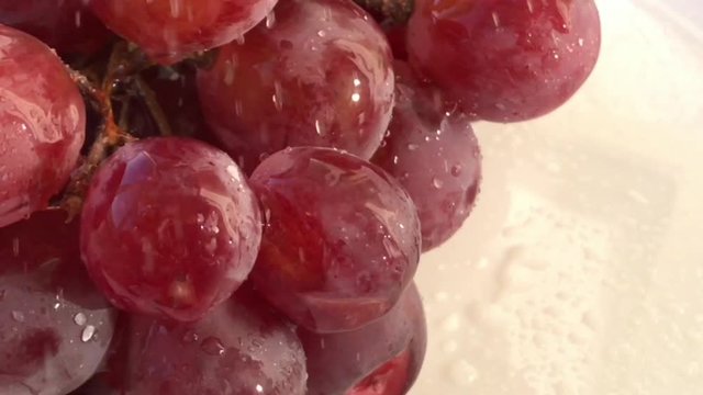 Another view: Red Grapes White background wet water droplet, authentic motion rain water droplets natural fruti