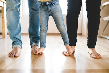 Beautiful young family. Bare feet of mother, father and daughter