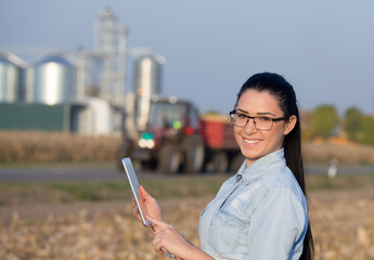 Farmer woman with tablet and silos