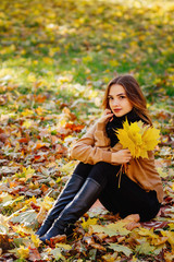 beautiful girl in Park , girl holding yellow leaves in the hand