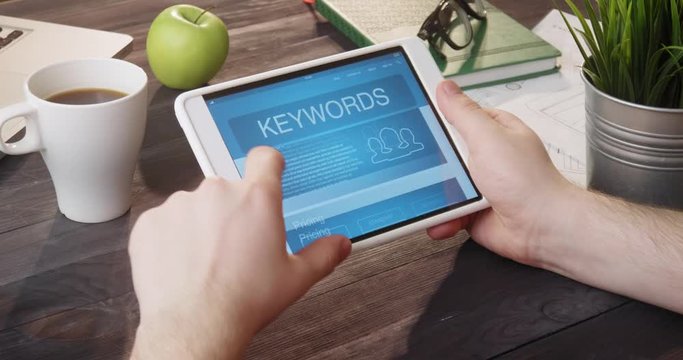 Looking at keywords internet page using digital tablet at desk