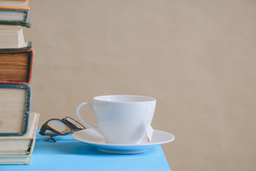 Book glasses and tea on the desk with study and education concept
