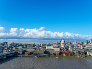 Fototapeta na wymiar London skyline with a view of St Paul's Cathedral, Millenium Bridge and skyscrapers of the north bank of the River Thames on a sunny day.