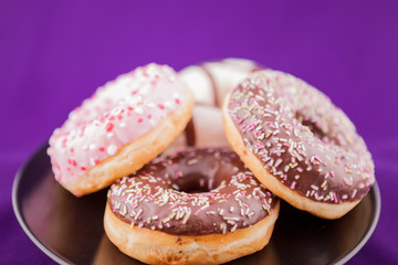 Donuts in plate over pink background. Delicious junk food