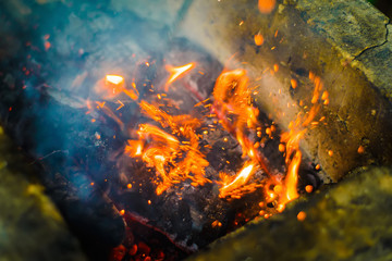 Hot sparking live-coals burning in a barbecue. small depth of field