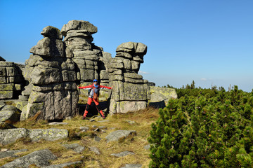 Hikings along tourist trails in the Karkonosze Mountain national park in Poland with the backpack on the back. Rock formation Czech stones