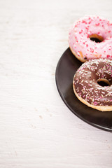 Close up of delicious donuts in black plate
