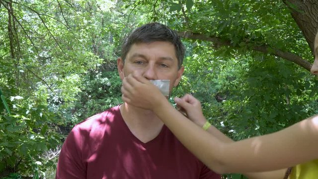 The men's mouth glued tape.Boy looks at the camera (emotion). This video can be used in films about freedom of speech and democracy