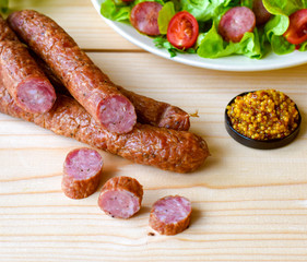 Smoked sausage with vegetables salad on a wooden board