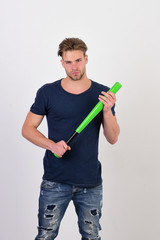 Guy in blue tshirt holds bright green bat for baseball