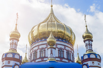 Fototapeta na wymiar Golden domes with crosses and Gold leaf of the Orthodox Church. lens flare