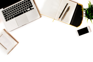 Modern minimalistic work place. White office desk table with laptop, smart phone, office plant, notebook, pen and pencil. Top view with copy space, flat lay