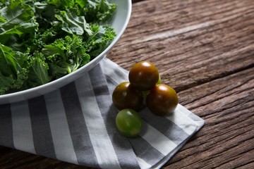 Mustard greens and gooseberry on wooden table