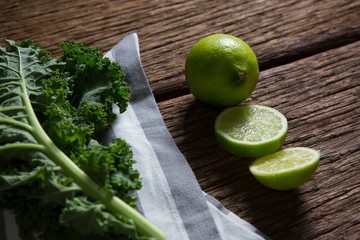 Mustard greens and lemon on wooden table