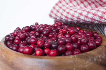 Berries cranberries in a wooden handmade dish on a light background