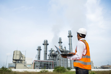 Engineer is checking gas turbine electric power plant by notebook