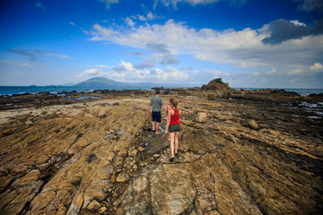 Backside Guy Blonde Girls Walk along Rocky Coast