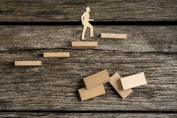 Silhouette cutouts of a man walking up wooden steps