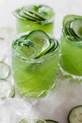 Cucumber and lime alcoholic cocktails on white marble surface