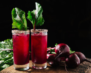 Red beet juice and gin cocktail on rustic background