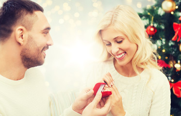 man giving woman engagement ring for christmas