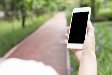 hand hold mobile phone in the garden