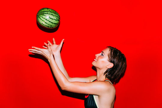 Woman throwing and catching a watermelon