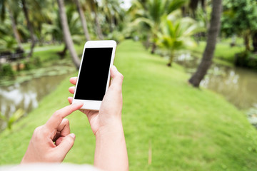 hand hold mobile phone in the garden