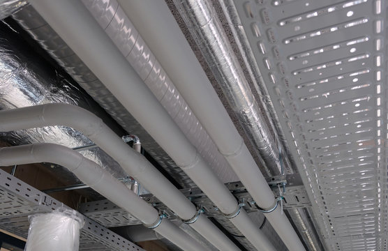 Heating and water cooling pipes attached to ceiling in office buidling