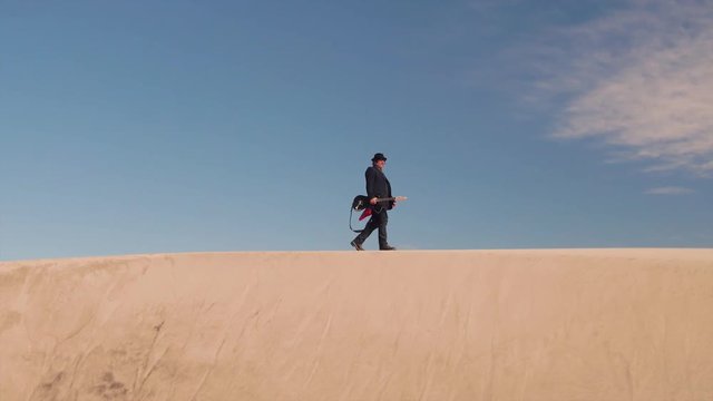 Rock star walking On the sand dunes of Mojave Desert music life in Palm Springs California area summer fall sunset