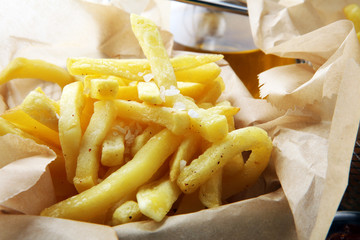 french fries, chips on wooden background with salt