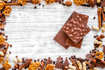 Cook homemade chocolate. Chocolate bars, nuts, sugar, coffee beans, cinnamon on grey wooden background top view copyspace