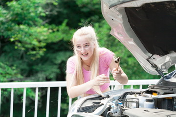 Girl in road car, pink t-shirt, car repairs, fun. Close up