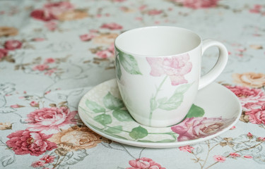cup on a floral tablecloth