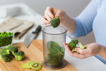 woman hand adding broccoli to measuring cup