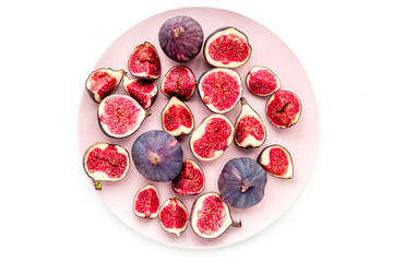 Plate of fresh blue figs on white background top view