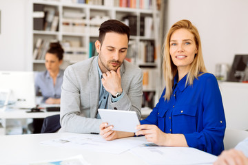 Fototapeta premium Colleagues discussing ideas on tablet