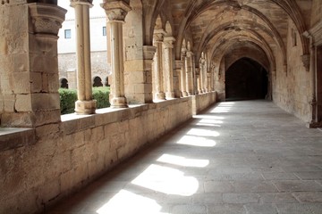 Columnas en un claustro con reflejos del sol