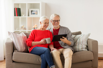 happy senior couple with tablet pc at christmas