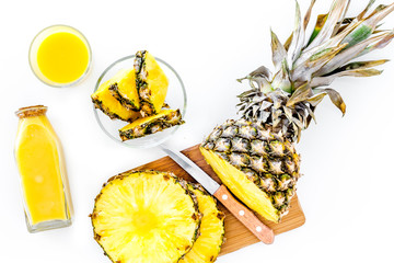 Preparing pineapple juice. Cut slices of pineapple with a knife on white background top view