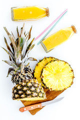 Preparing pineapple juice. Cut slices of pineapple with a knife on white background top view
