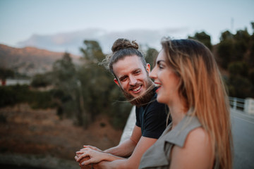 Portrait of bearded man laughing while look at her girlfriend in nature.