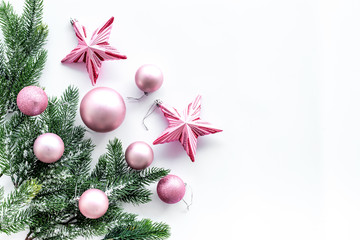 Christmas toys pattern. Pink stars and balls near pine branches on white background top view copyspace