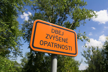 Dbej zvysene opatrnosti ( Be more careful ) - czech text on the orange traffic sign. Appeal to be cautious, vigilant and vary.