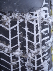 Naklejka premium Close-up of car tyre fasten with chain